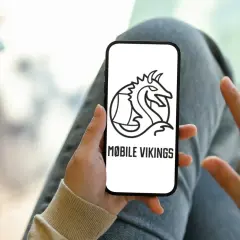 Ręka trzyma smartfon z logo Mobile Vikings. To sieć komórkowa dla tych, którzy cenią wolność i niezależność.