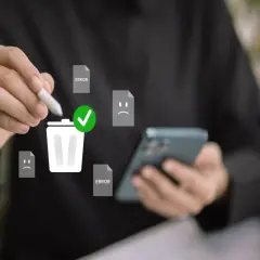 Ręka z rysikiem usuwa błędy i nieudane pliki, symbolizując czyszczenie telefonu.