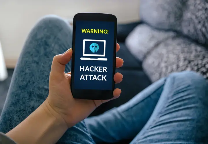 Ostrzeżenie na ekranie telefonu: "HACKER ATTACK". To może być efekt smishingu, czyli oszustwa przez SMS.