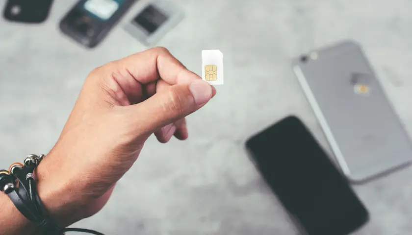 Dłoń trzyma kartę SIM, gotową do włożenia do telefonu. To idealne rozwiązanie dla osób szukających internetu na kartę bez umowy.