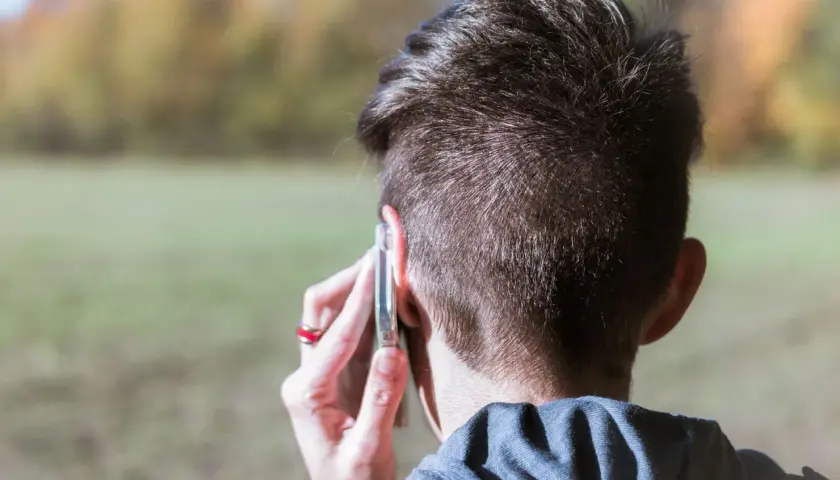 Mężczyzna rozmawia przez telefon, słychać numer kierunkowy +380.