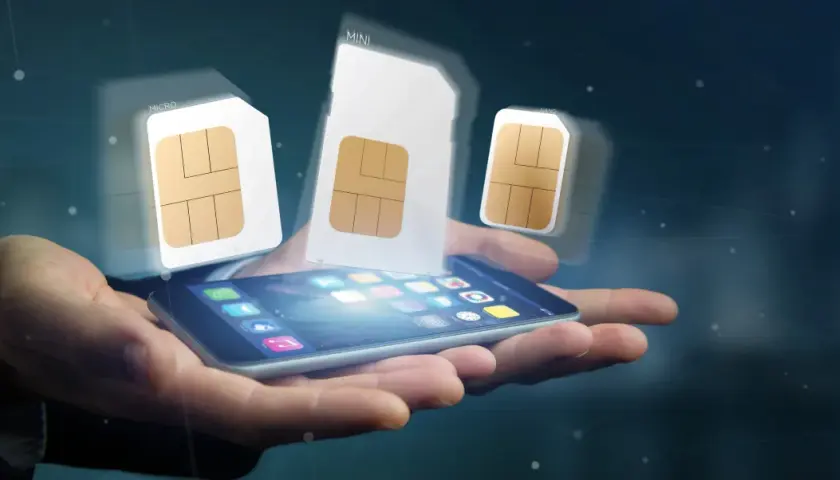 Dłoń trzyma smartfon, nad którym unoszą się karty SIM różnych rozmiarów, symbolizujące aktywację karty SIM i wybór odpowiedniego formatu.