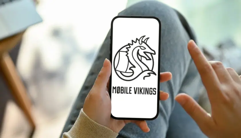 Ręka trzyma smartfon z logo Mobile Vikings. To sieć komórkowa dla tych, którzy cenią wolność i niezależność.