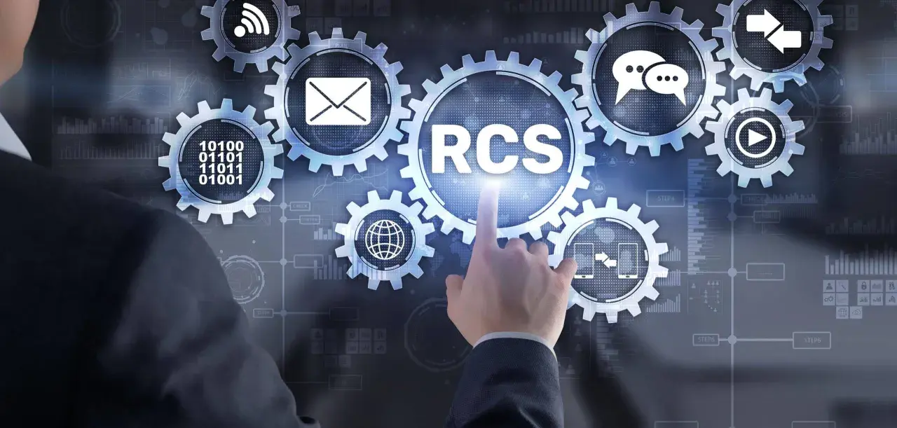 Dłoń wskazuje na koło zębate z napisem RCS, symbolizujące nowoczesną komunikację.